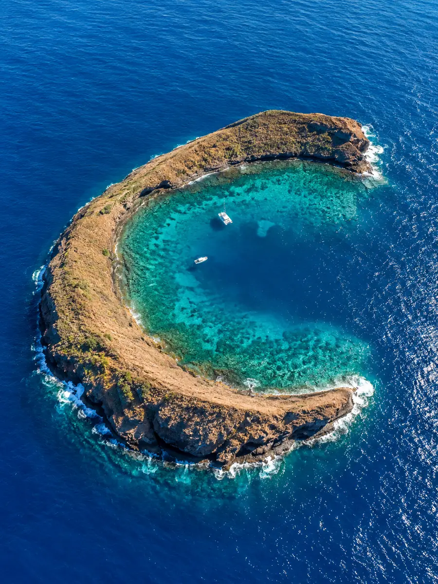 Aerial view of the crescent-shaped Molokini crater with a turquoise inner bay